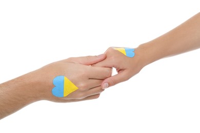 Photo of Man and woman with painted Ukrainian flags on their hands against white background, closeup