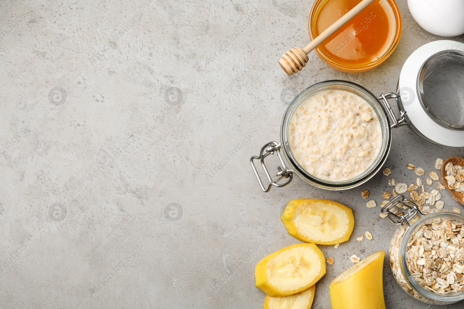 Photo of Handmade face mask and ingredients on grey table, flat lay. Space for text