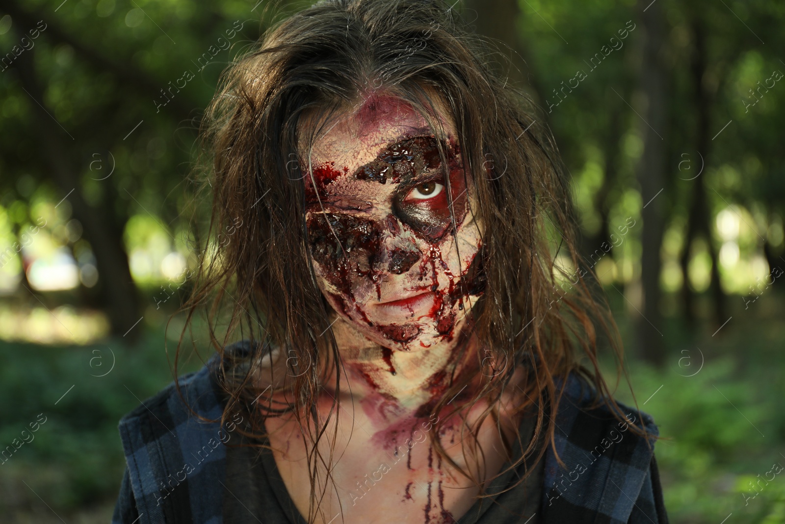 Photo of Scary zombie with bloody face outdoors. Halloween monster