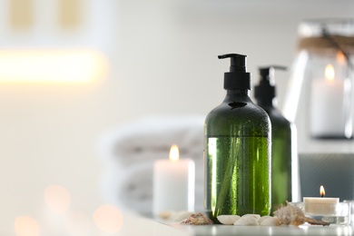 Photo of Soap dispensers and decor elements on table. Space for text