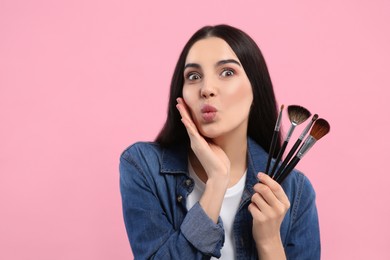 Photo of Woman with different makeup brushes on pink background. Space for text