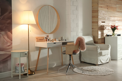 Stylish room interior with dressing table and mirror