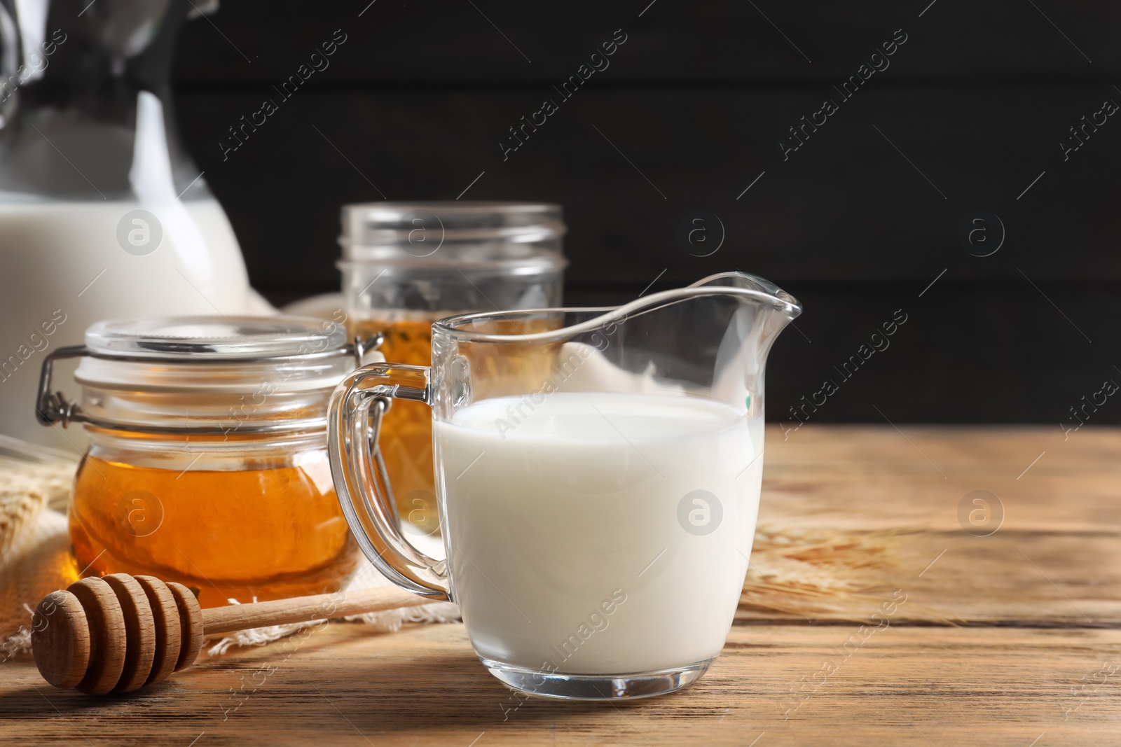 Photo of Beautiful composition with milk and honey on wooden table