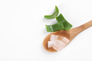 Photo of Aloe vera gel in spoon and slices of plant on white background, top view. Space for text