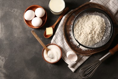 Different ingredients for dough on grey textured table, flat lay. Space for text