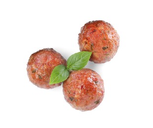 Tasty cooked meatballs with basil on white background, top view