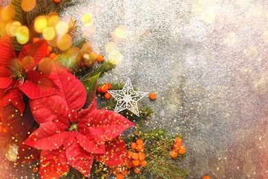 Image of Flat lay composition with traditional Christmas poinsettia flowers and space for text on grey table, bokeh effect