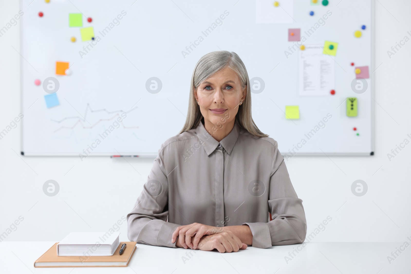 Photo of Portrait of professor sitting at desk in classroom