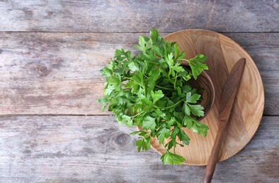 Photo of Flat lay composition with fresh green parsley and space for text on wooden background