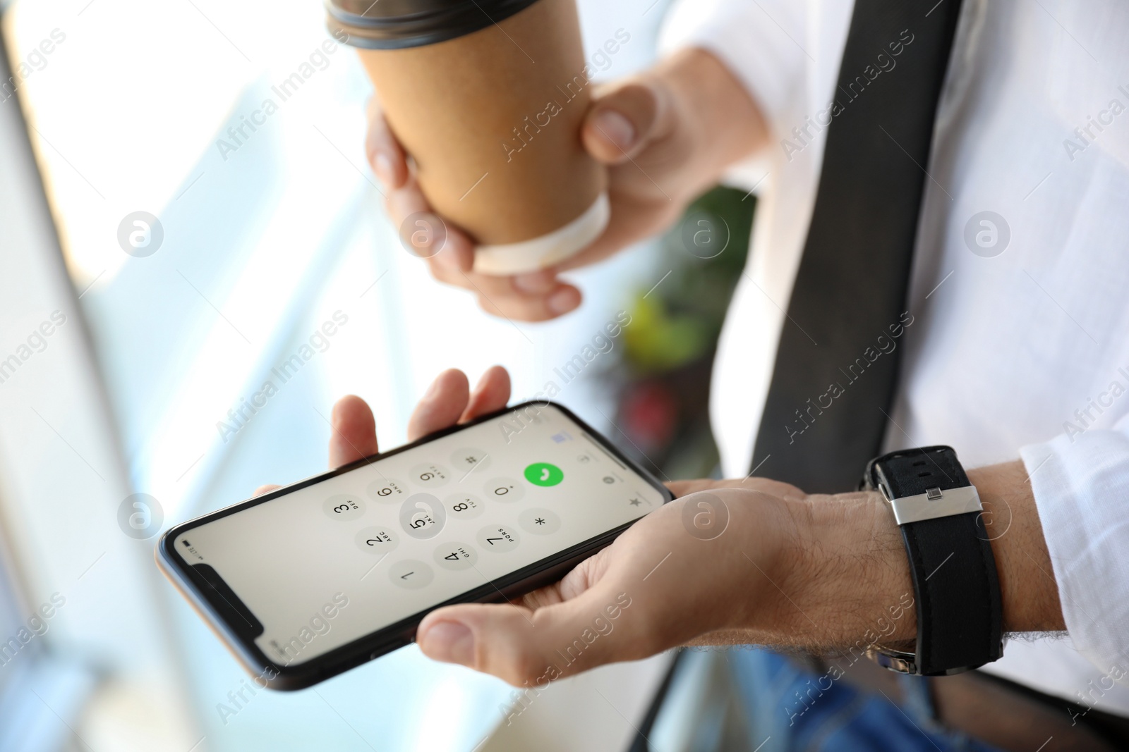 Photo of MYKOLAIV, UKRAINE - MARCH 16, 2020: Man holding iPhone 11 with keypad on screen indoors, closeup