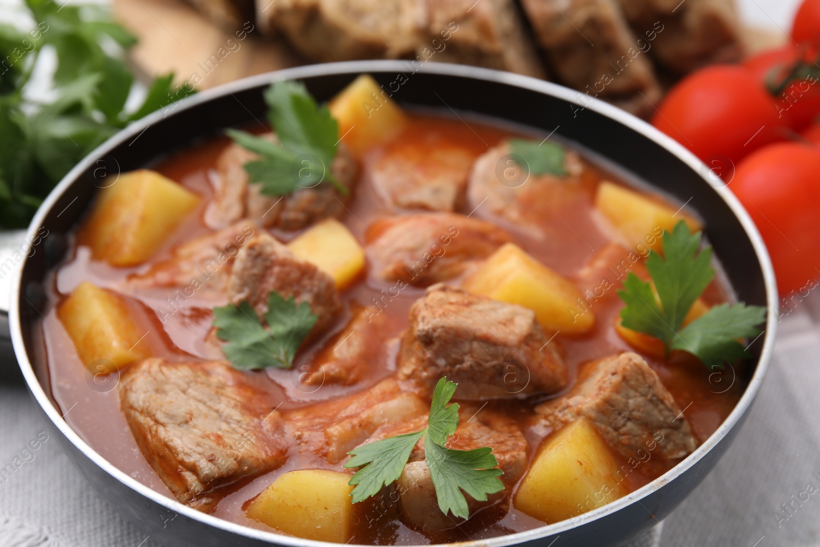 Photo of Delicious goulash in saucepan on table, closeup