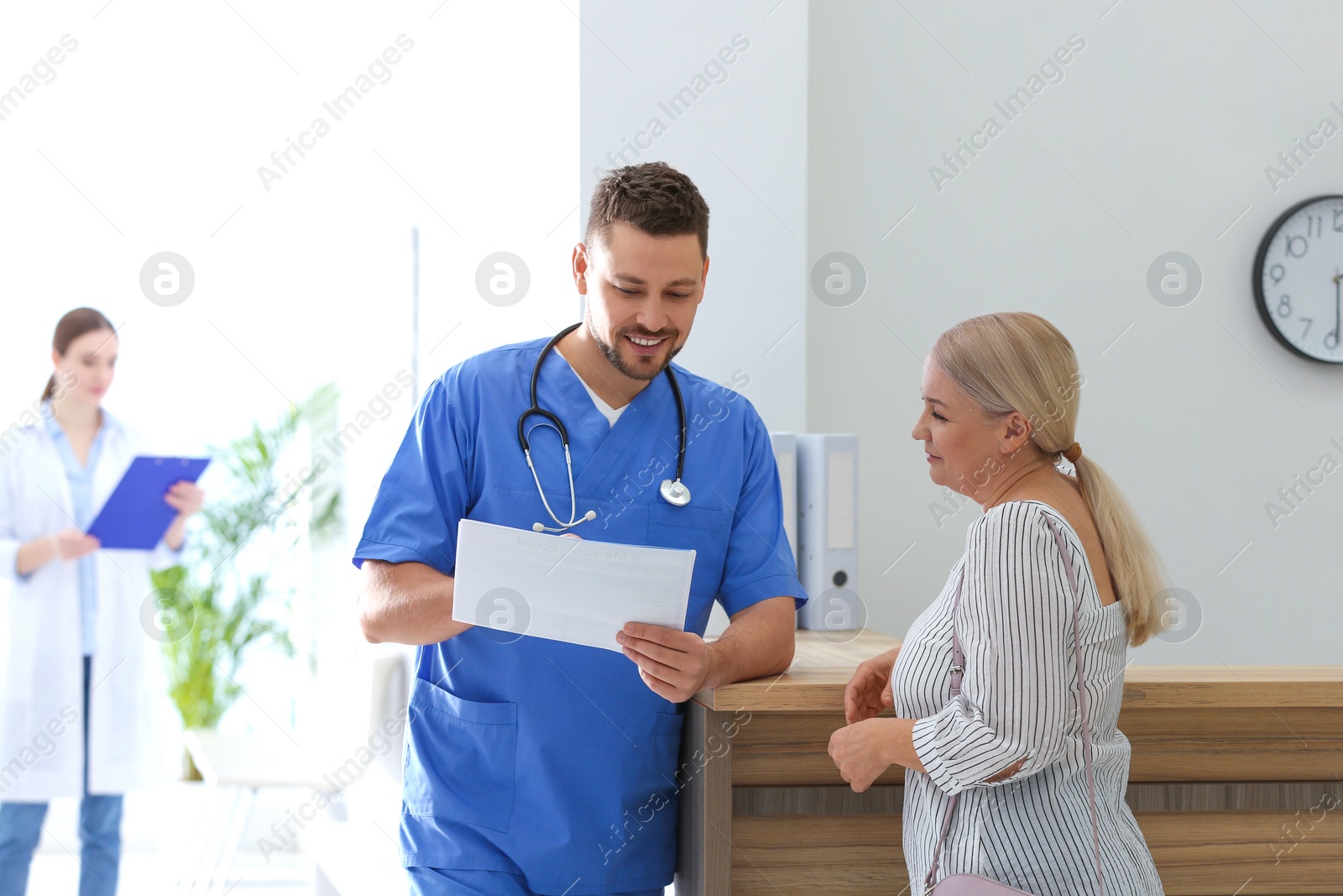 Photo of Doctor talking with patient in hospital hall