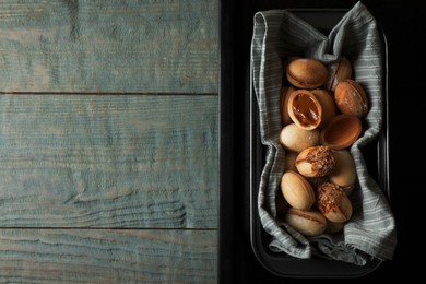 Photo of Freshly baked homemade walnut shaped cookies with condensed milk on wooden table, top view. Space for text