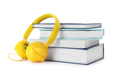 Photo of Modern headphones with hardcover books on white background