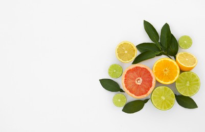 Photo of Different citrus fruits and leaves on white background, top view