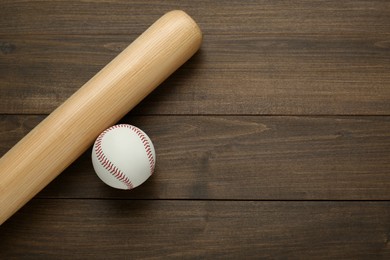 Photo of Baseball bat and ball on wooden table, top view with space for text. Sports equipment