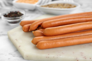 Photo of Fresh delicious sausages on white marble table