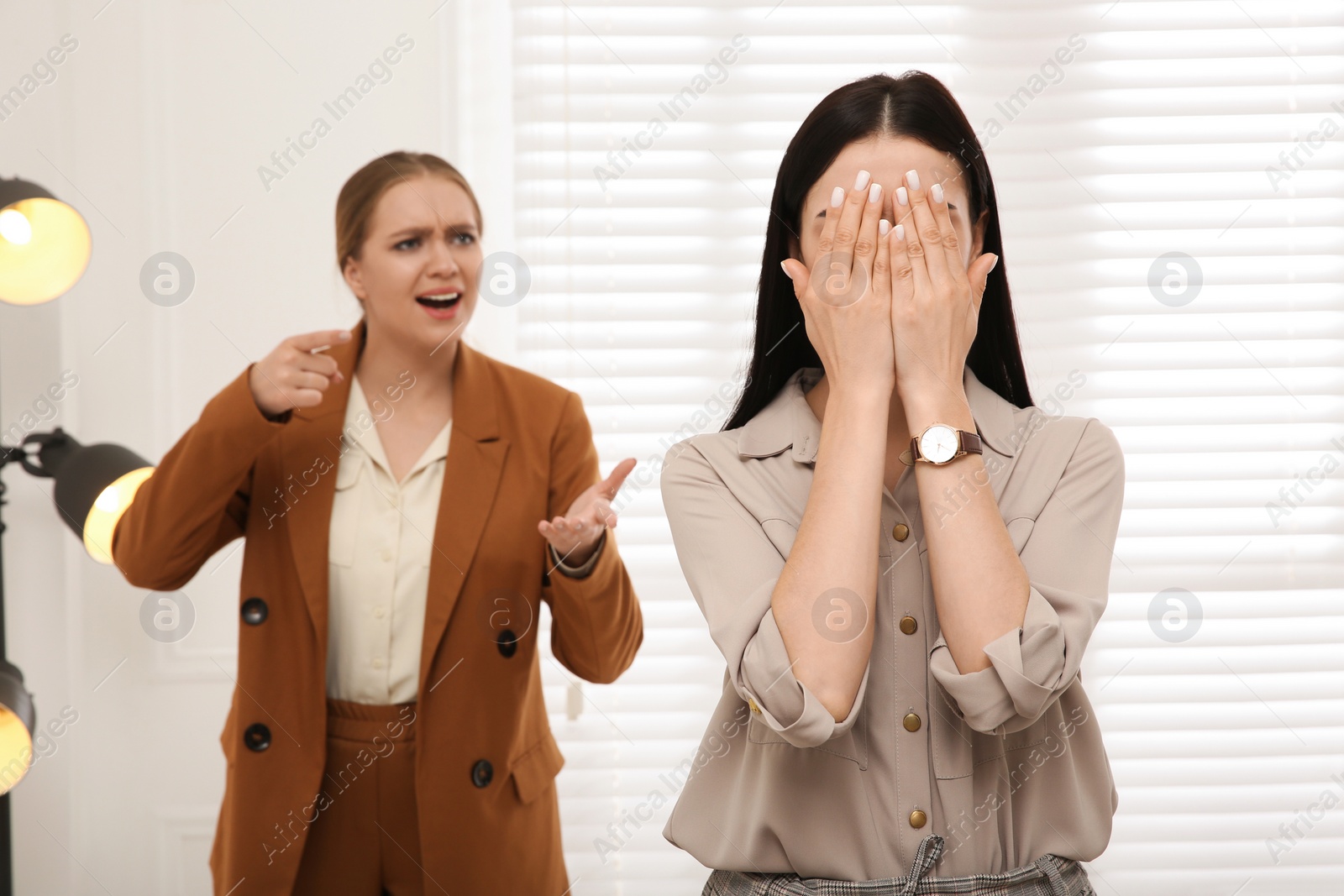 Photo of Boss screaming at employee in office. Toxic work environment