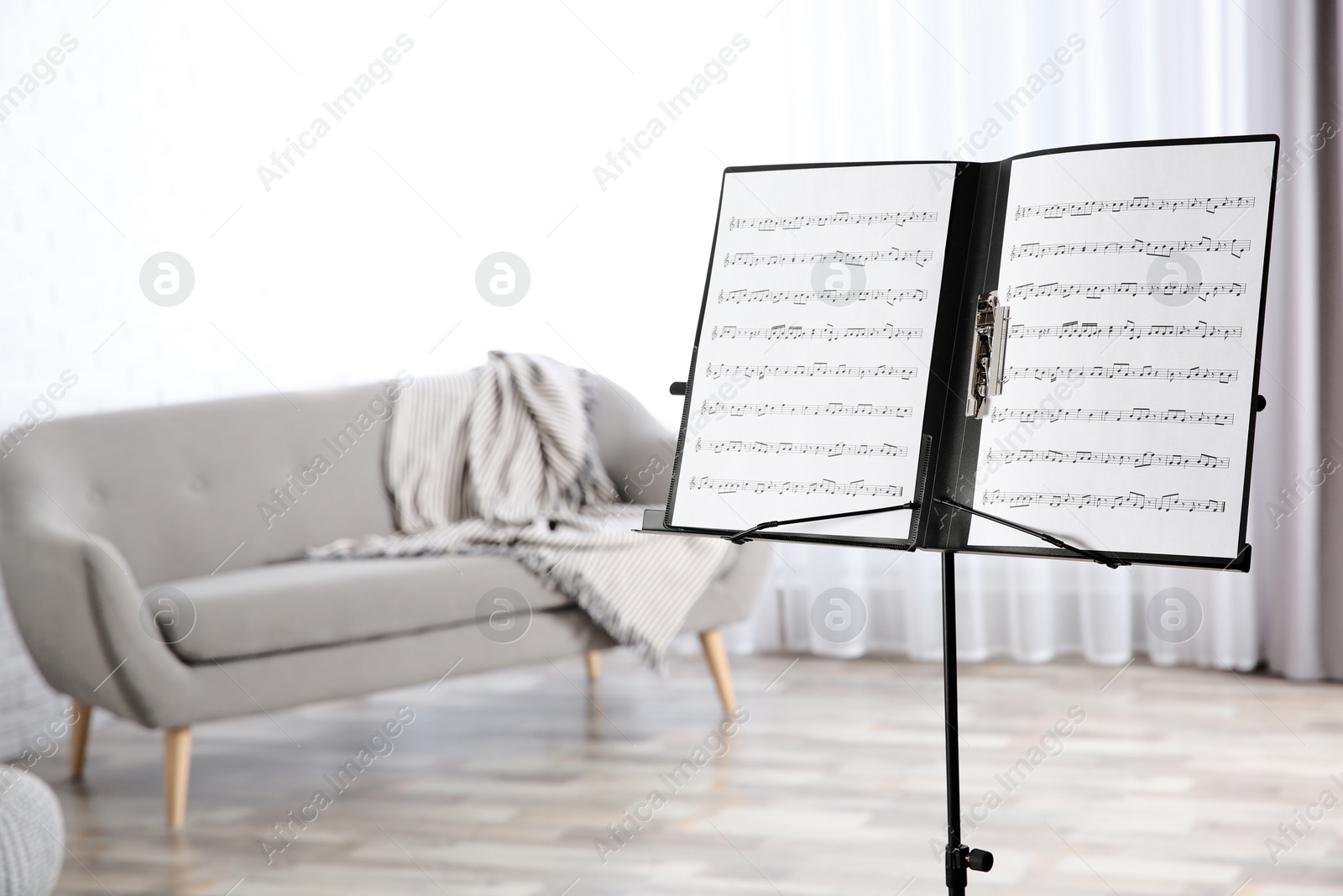 Photo of Note stand with music sheets indoors. Space for text