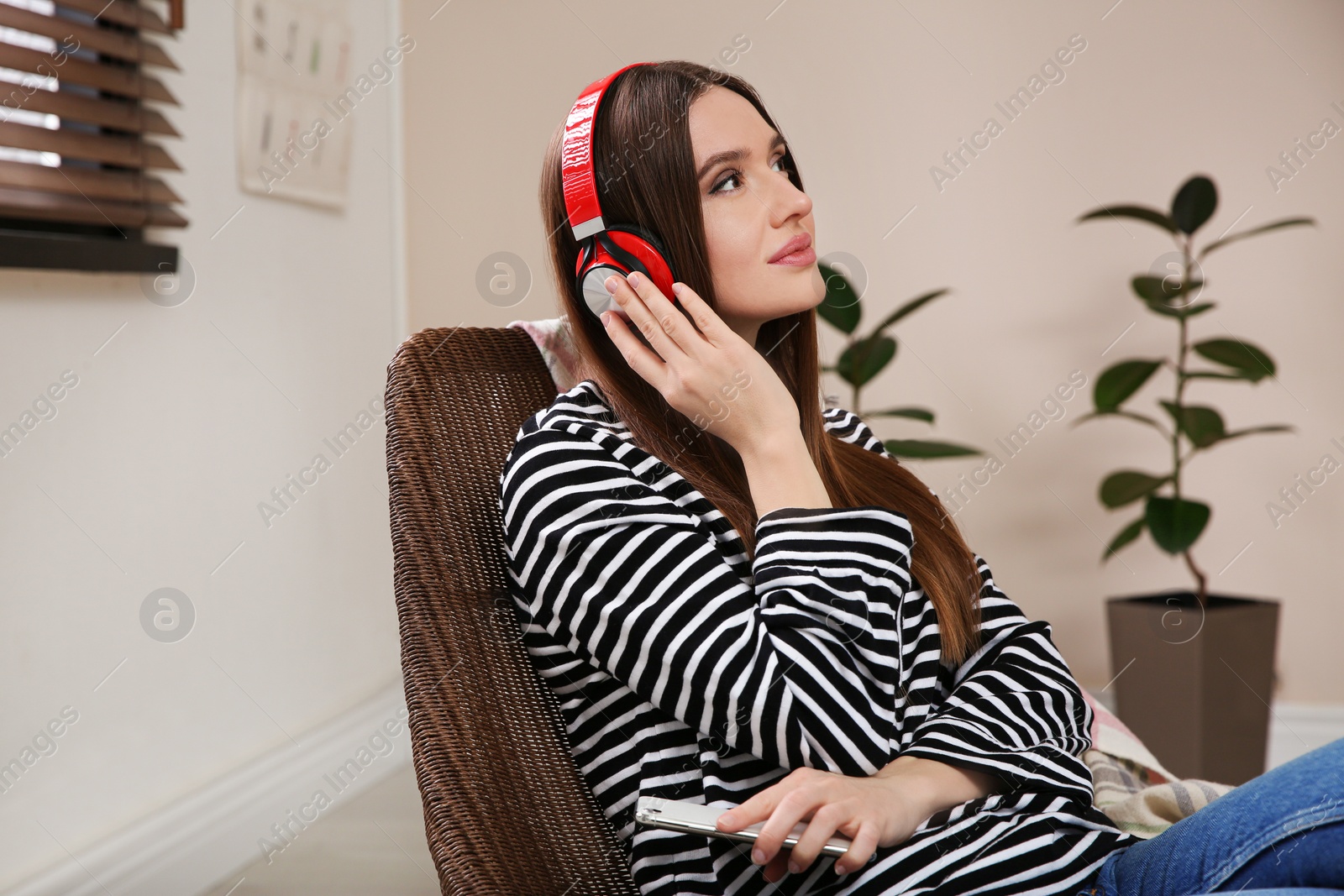 Photo of Woman listening to audiobook in chair at home
