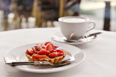 Photo of Plate with tasty dessert and cupfresh coffee on round table in morning