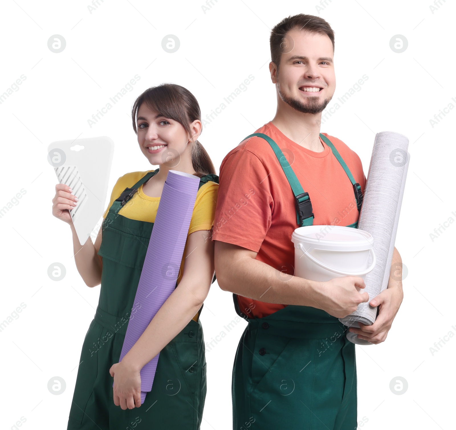 Photo of Workers with wallpaper rolls, bucket of glue and spatula on white background