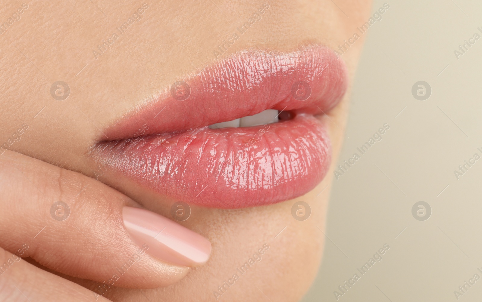 Photo of Woman with beautiful full lips on beige background, closeup