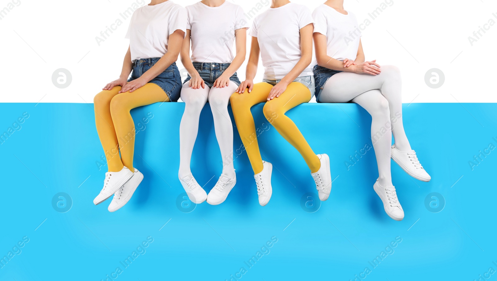 Photo of Group of women wearing colorful tights and stylish shoes sitting on color background, closeup