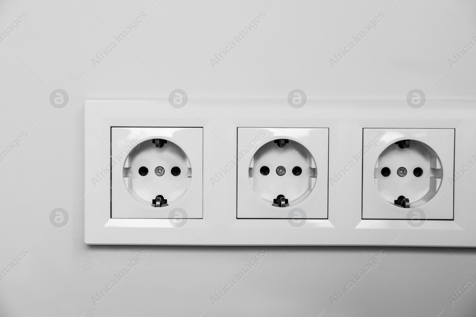 Photo of Power sockets on white wall. Electrical supply