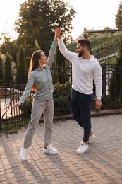 Lovely couple dancing together outdoors at sunset