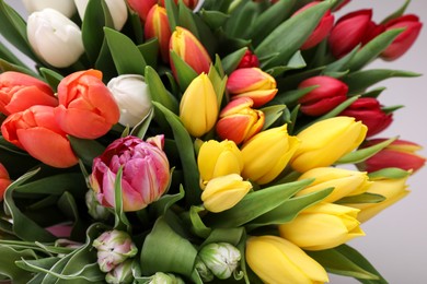 Photo of Beautiful colorful tulip flowers on light grey background, closeup with above view