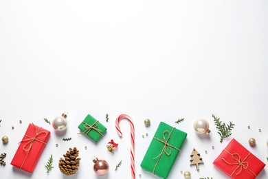 Flat lay composition with Christmas gifts and festive decor on white background. Space for text