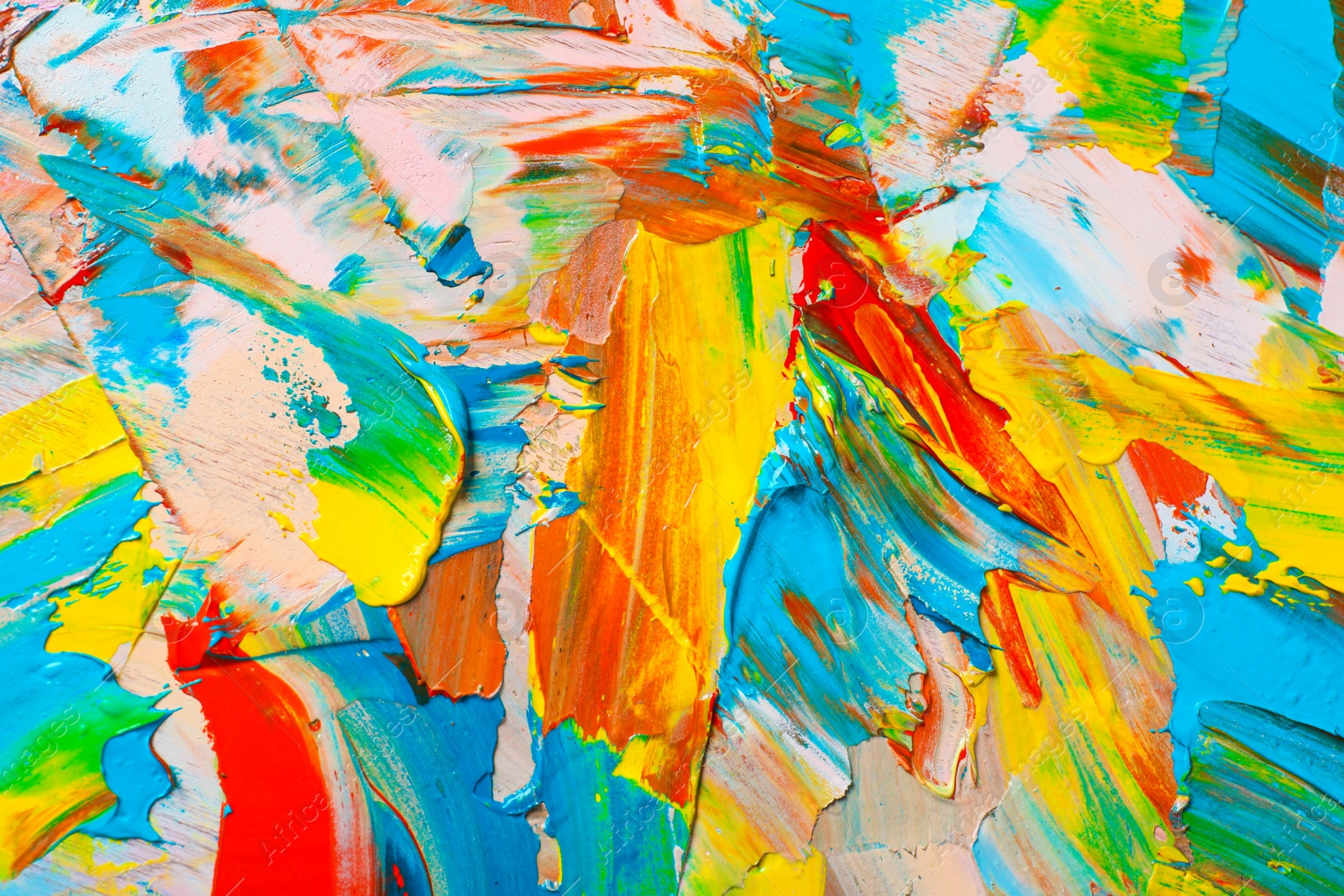 Photo of Closeup view of artist's palette with mixed bright paints as background