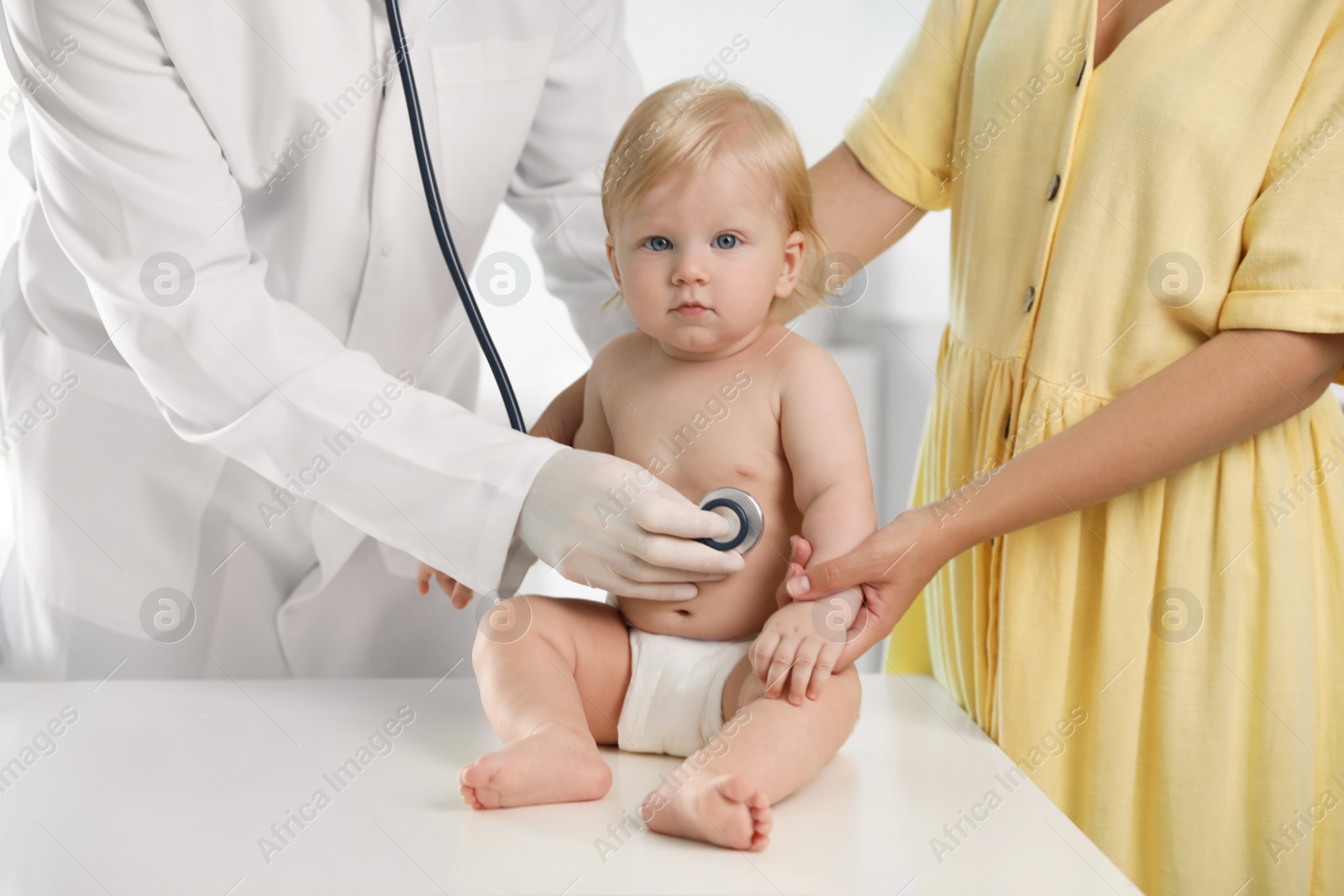 Photo of Pediatrician examining baby with stethoscope in hospital. Health care