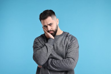 Photo of Portrait of sad man on light blue background