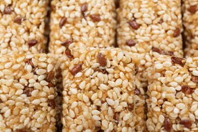 Tasty sesame seed bars as background, closeup