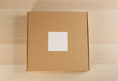 Photo of Cardboard box on wooden table, top view