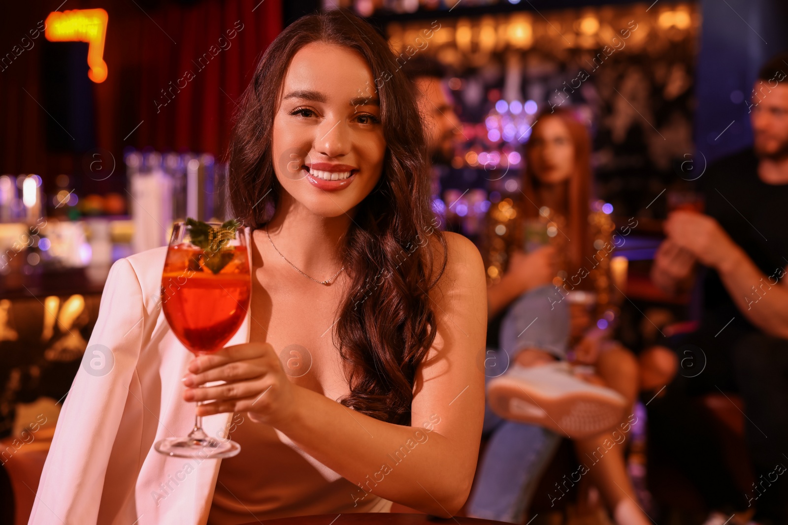 Photo of Friends spending time together in bar. Beautiful woman with fresh alcoholic cocktail, space for text