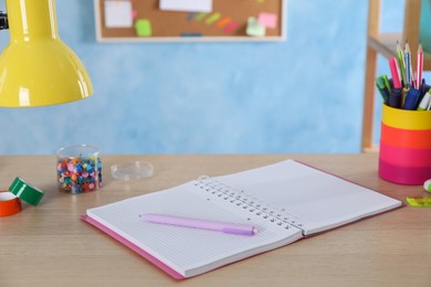 Notebook and pen on wooden desk in room