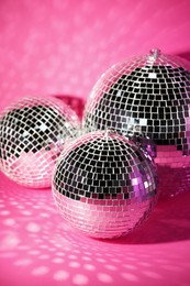 Many shiny disco balls on pink background