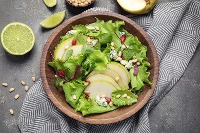 Photo of Fresh salad with pear on grey table, flat lay