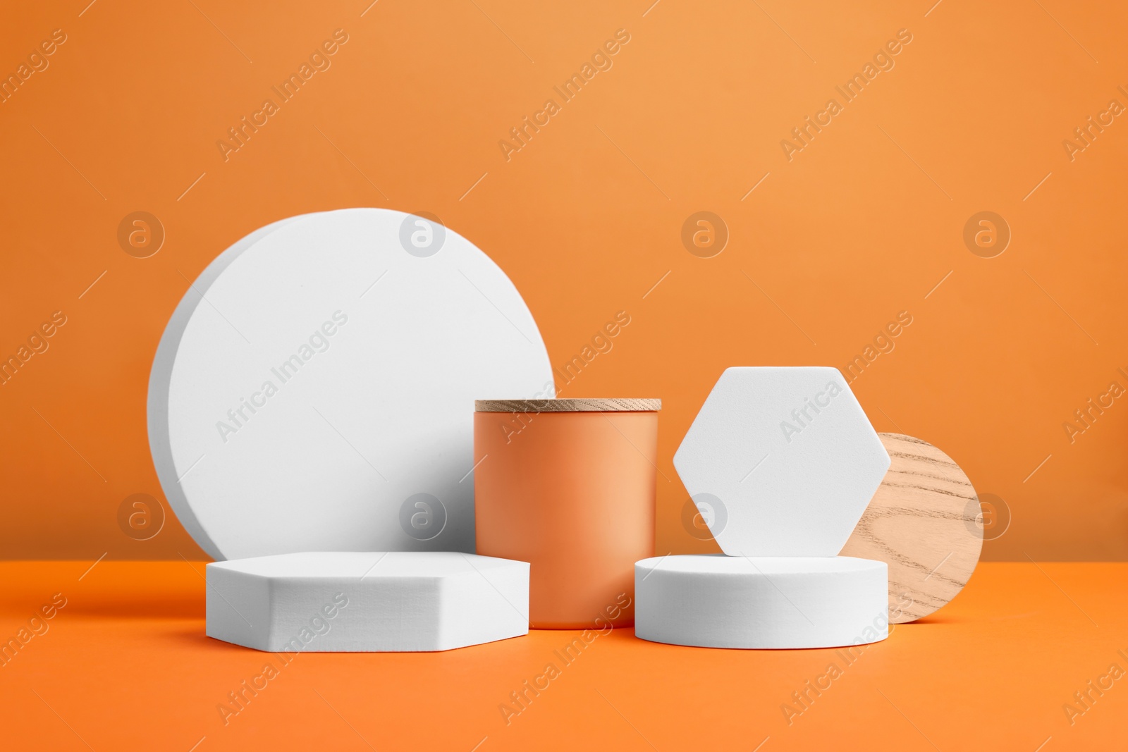 Photo of Scene for product presentation. Podiums of different geometric shapes on orange background