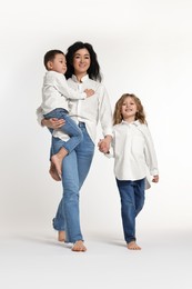 Photo of Little children with their mother on white background