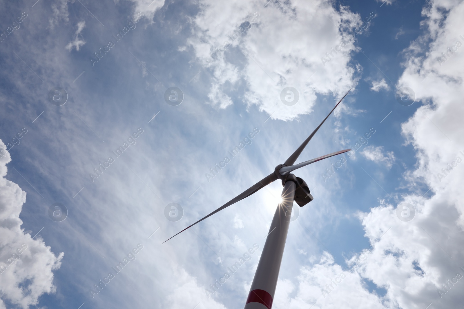 Photo of Modern wind turbine against cloudy sky, low angle view. Alternative energy source