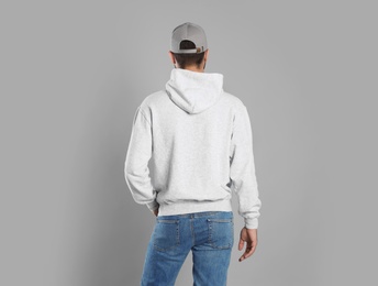 Photo of Young man in sweater on grey background. Mock up for design