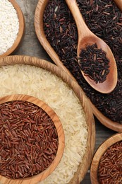 Different sorts of rice on wooden table, flat lay