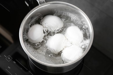 Chicken eggs boiling in saucepan on electric stove, above view