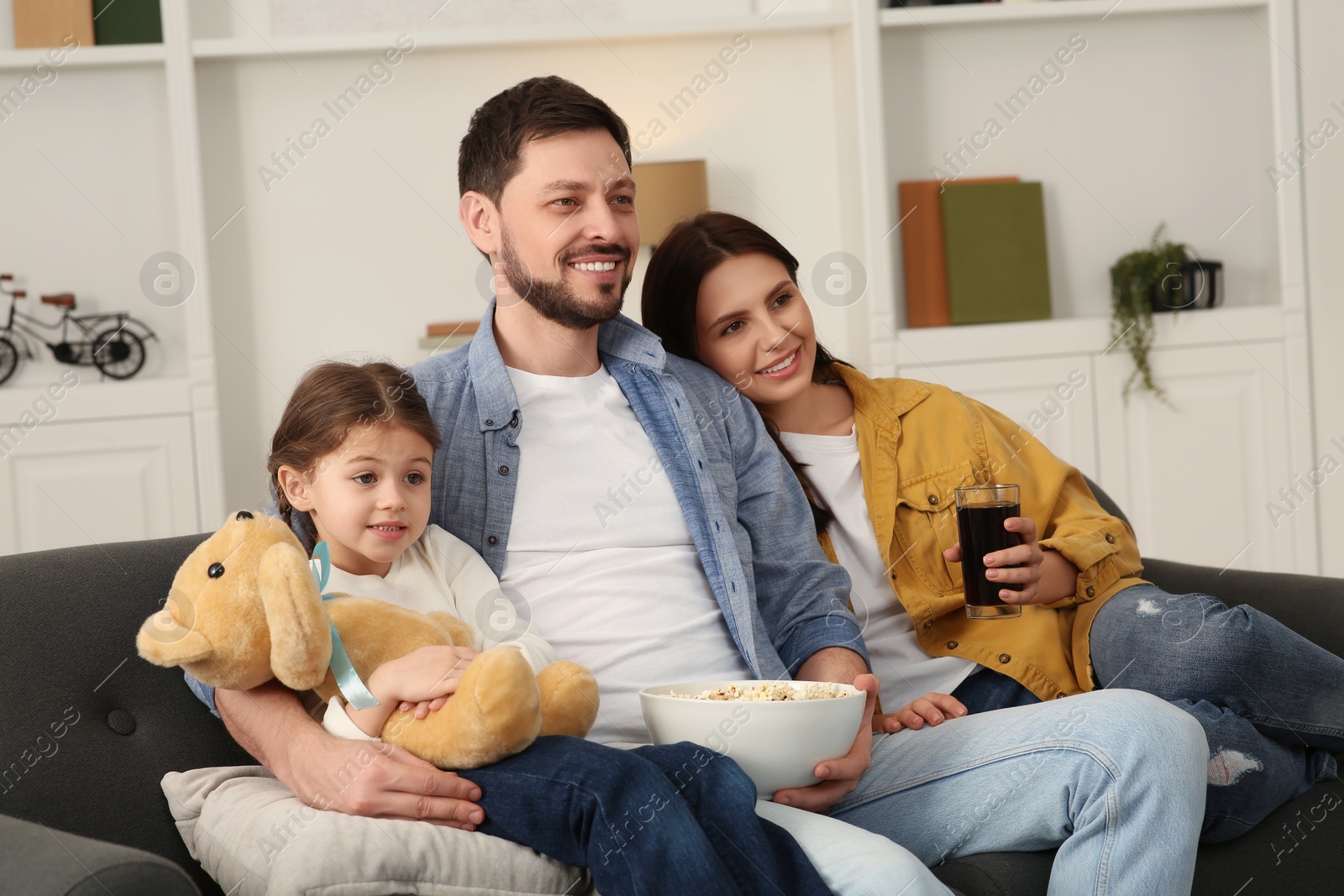 Photo of Happy family watching TV on sofa at home