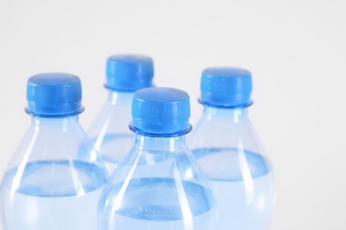 Photo of Plastic bottles with pure water on white background, closeup