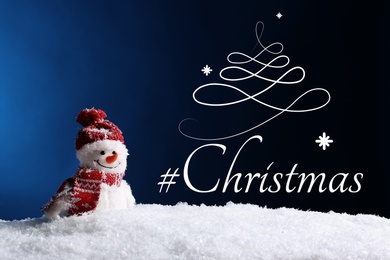 Image of Decorative snowman in snow and hashtag Christmas on color background
